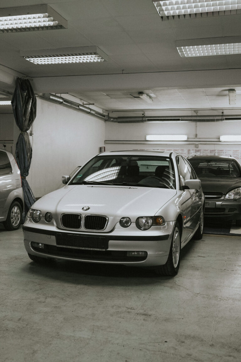 Silberner BMW in der Werkstatt von WerksKolleg unter Neonlicht.